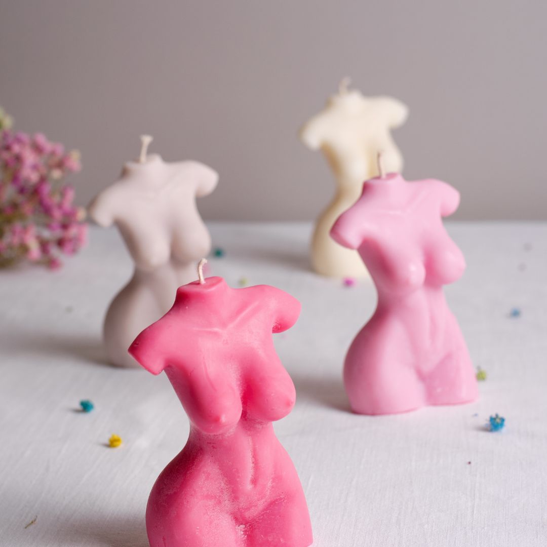 flere forskellige former og farver af sojalys i en kvindeform